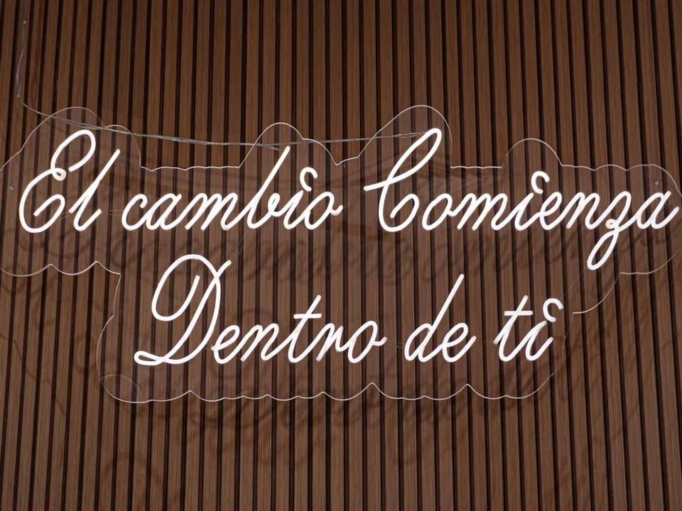 Detalle del letrero "El cambio comienza dentro de ti" en la pared de madera
